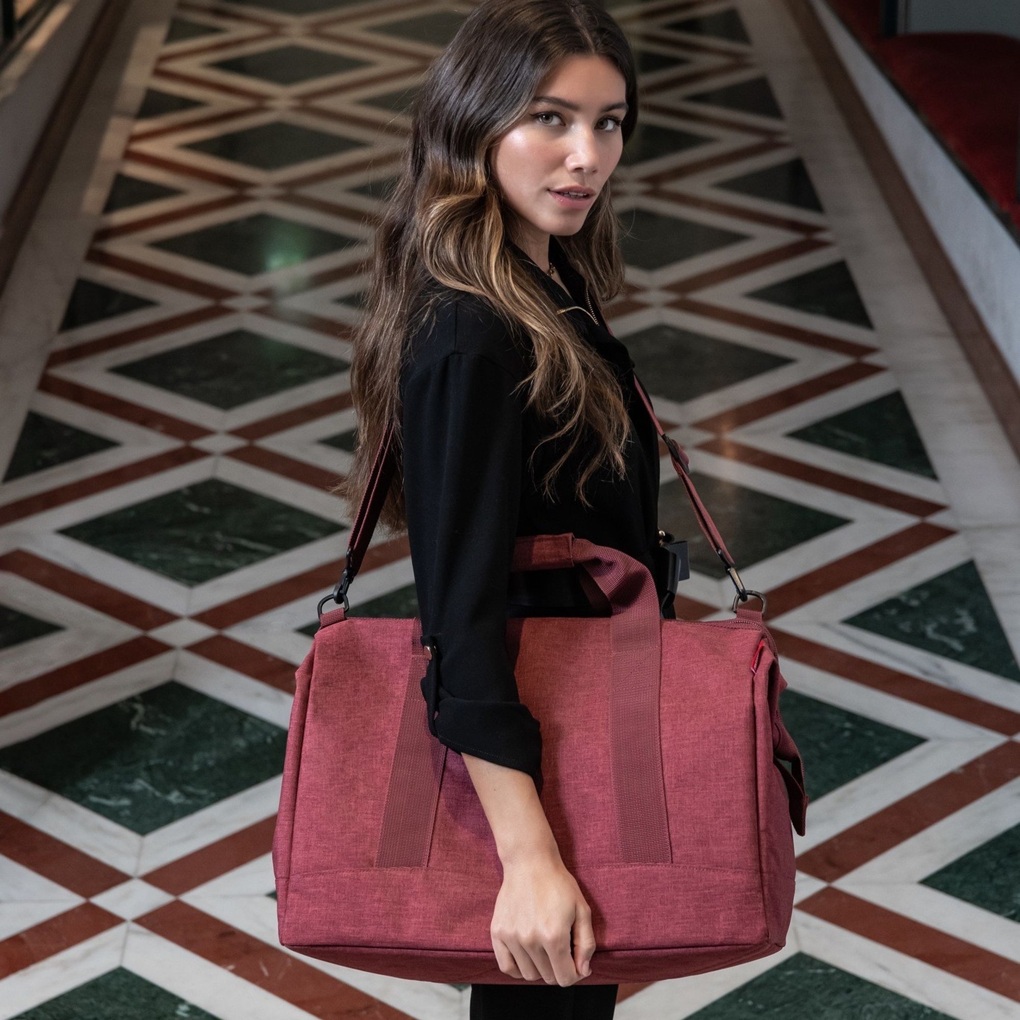 Frau trägt elegante rote Schultertasche