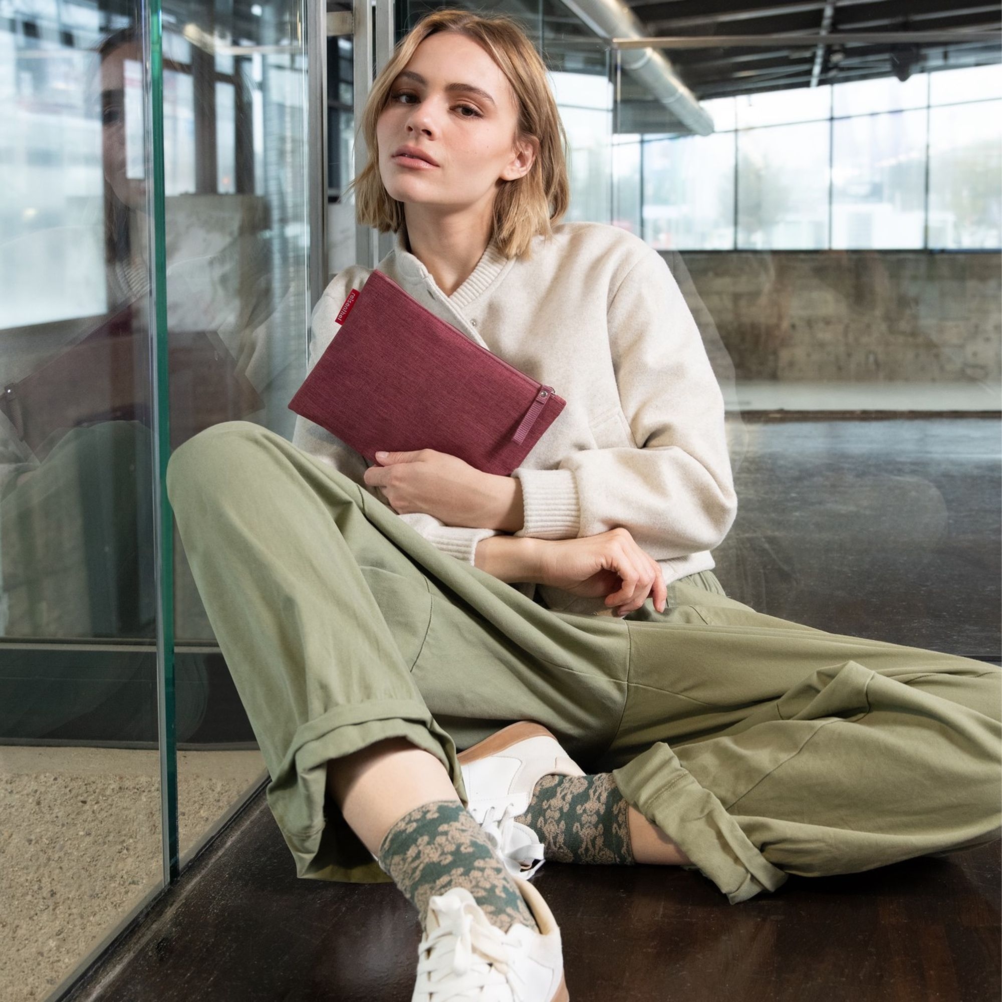 Frau mit roter Stofftasche, lässiges Streetwear-Outfit
