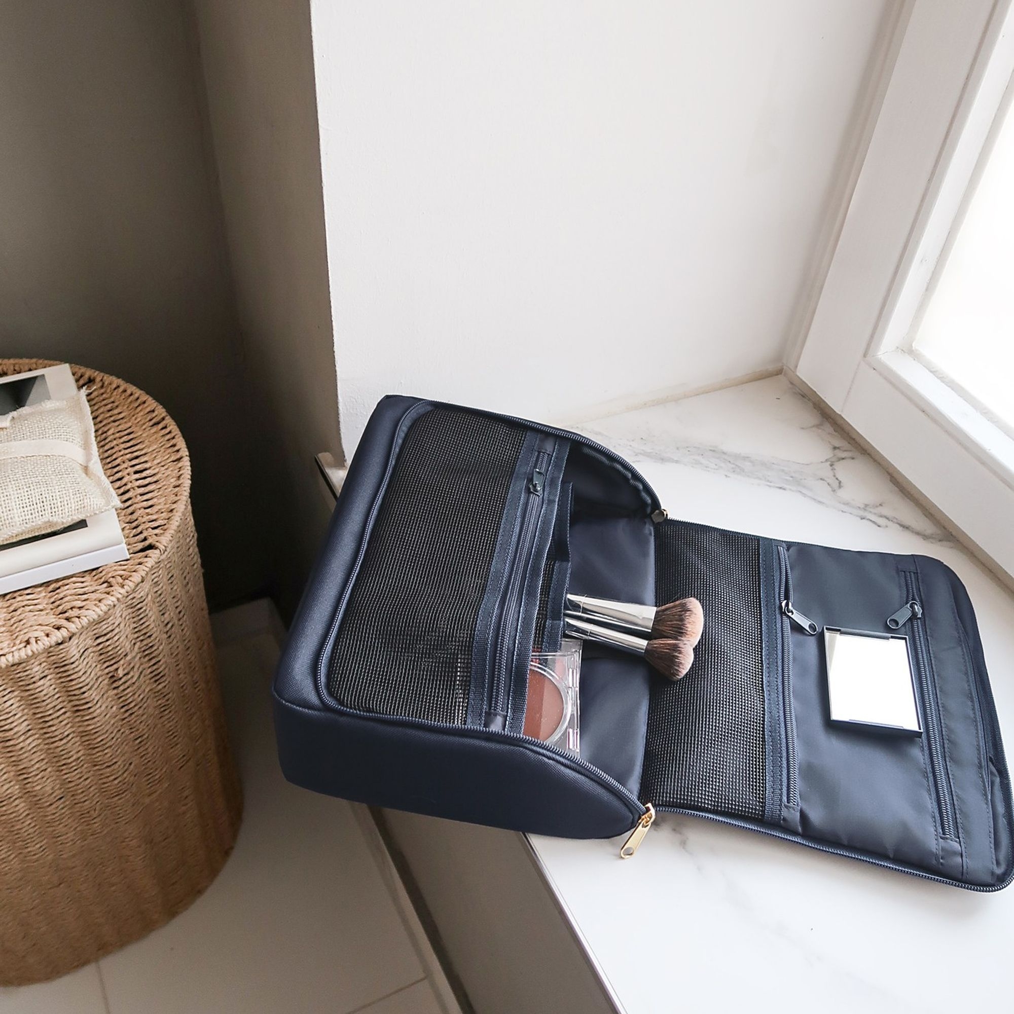 Geöffnete dunkelblaue Kosmetiktasche mit Make-up