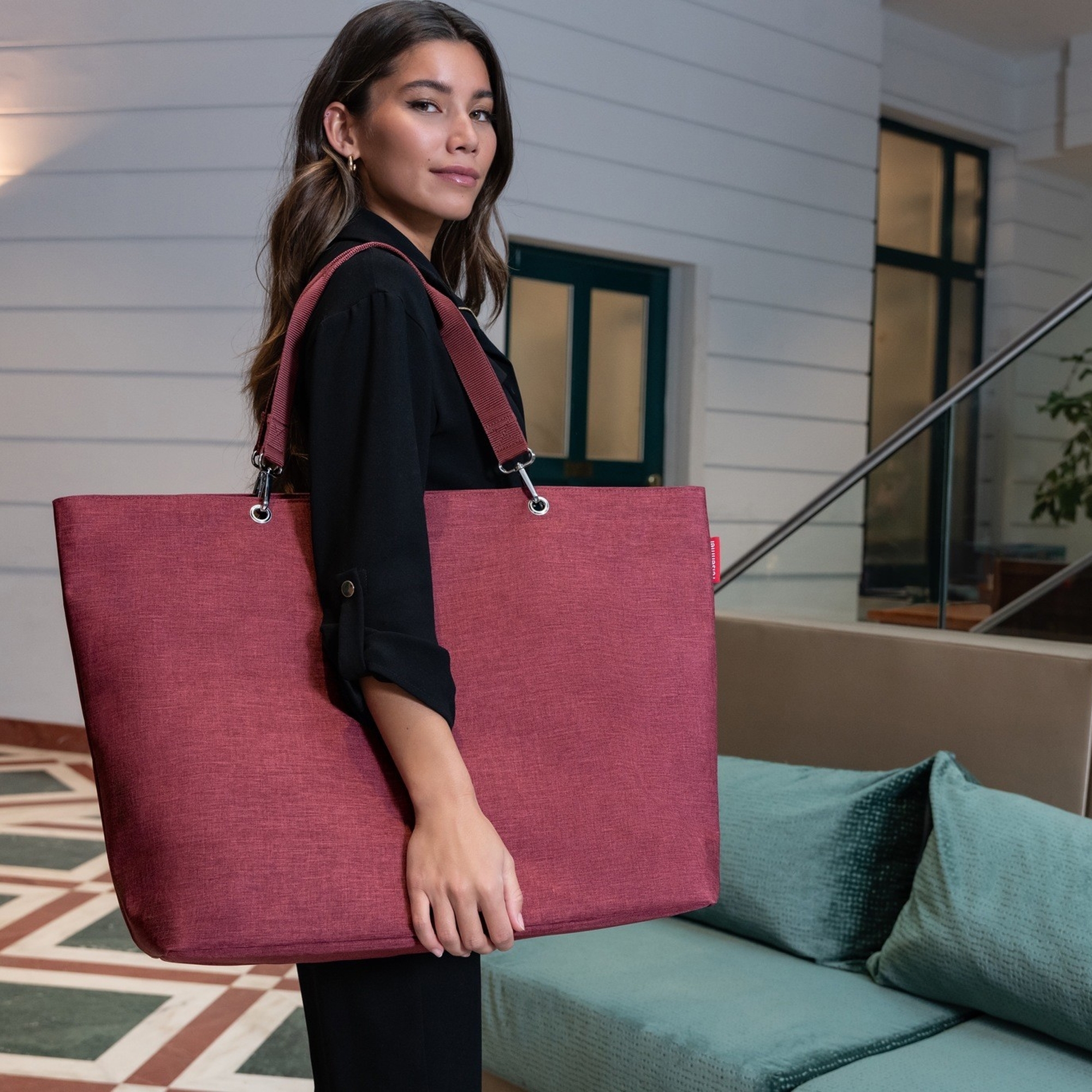 Frau mit großer roter Schultertasche im Innenraum