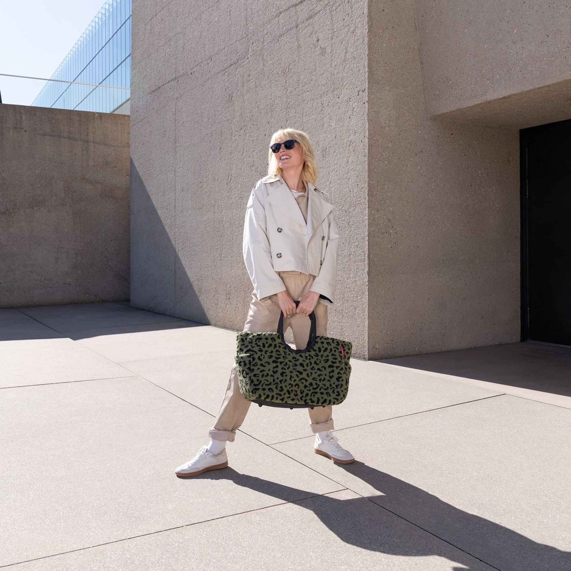 Frau trägt modische grüne Schultertasche mit Animal-Print