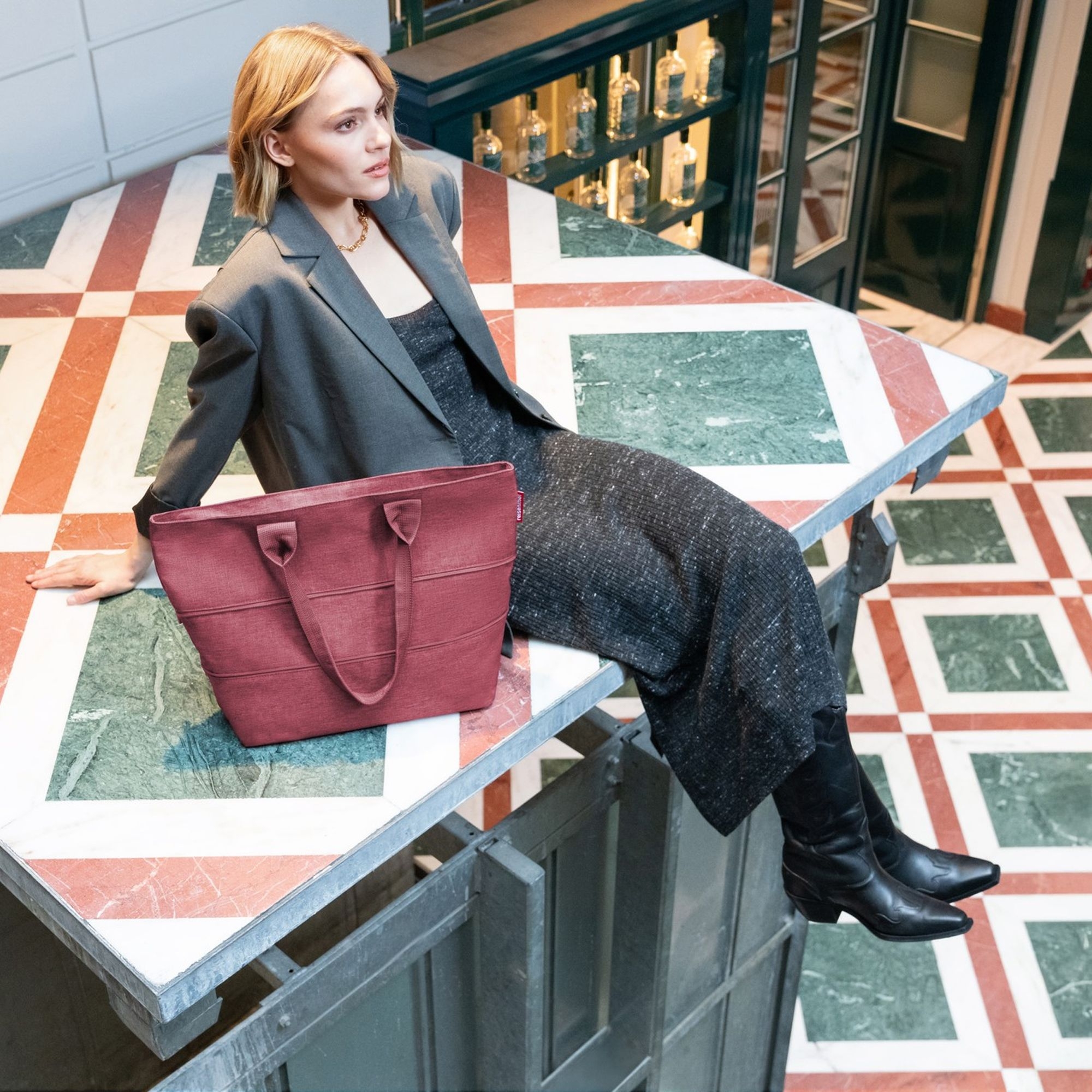 Rote Damen-Shopper Tasche neben Frau im Blazer